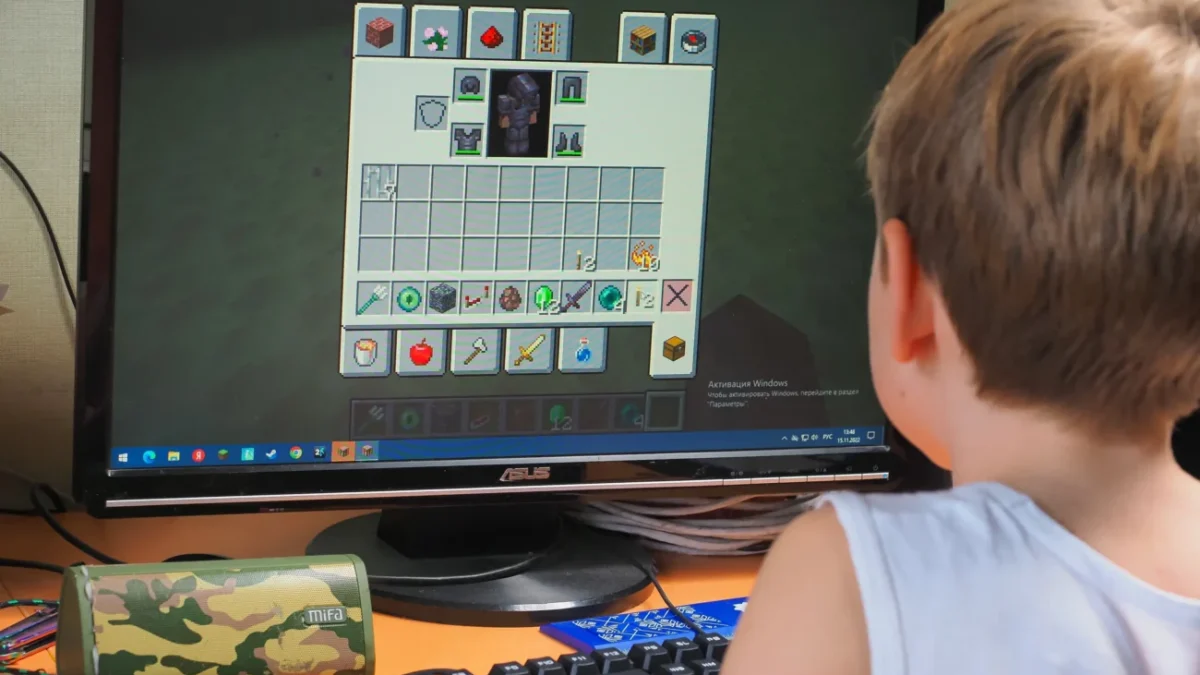 Chlapeček sedí u Minecraftu.