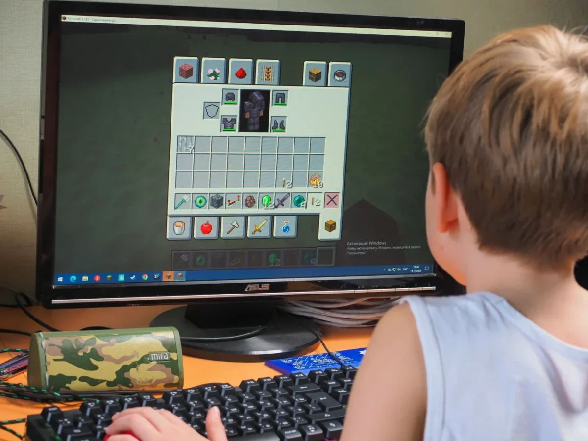 Chlapeček sedí u Minecraftu.