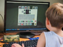 Chlapeček sedí u Minecraftu.