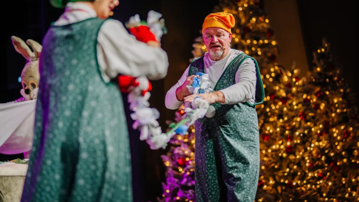 Muž je oblečený jako vánoční skřítek.