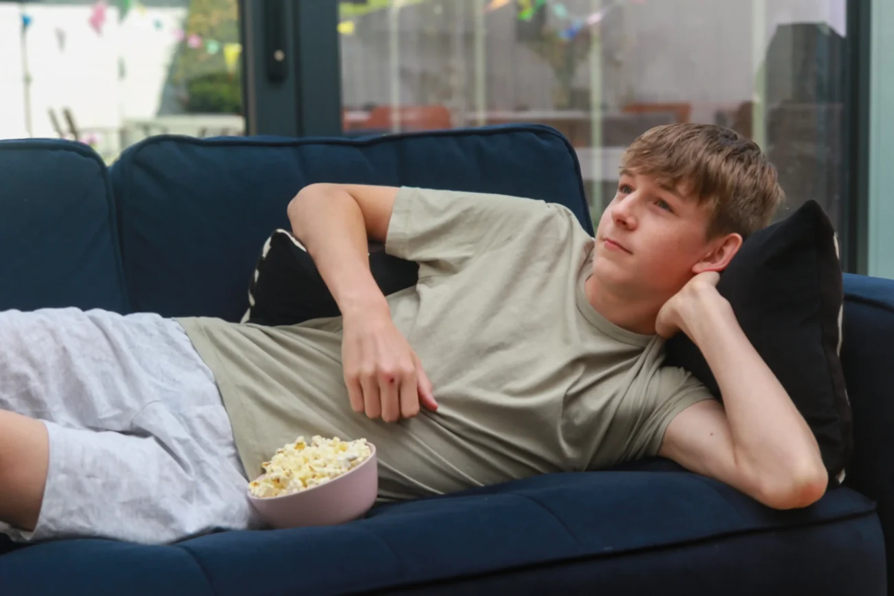 Chlapec leží na gauči. 