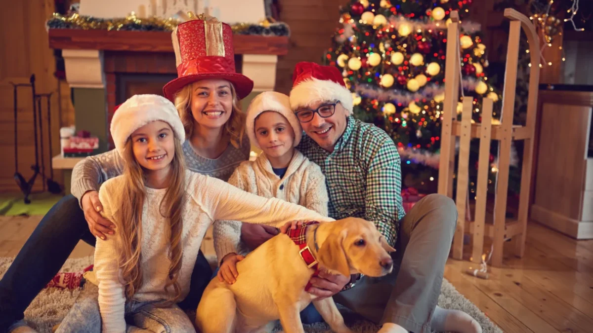Rodina sedí před vánočním stromkem.