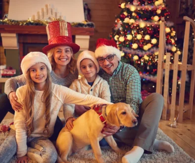 Rodina sedí před vánočním stromkem.