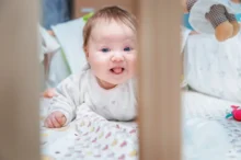 Miminko leží v postýlce.