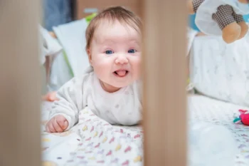 Miminko leží v postýlce.