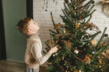 Chlapeček zírá na vánoční strom.