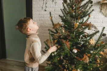 Chlapeček zírá na vánoční strom.