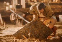 archeolog vytahuje starou desku ze země