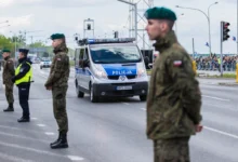 Policisté stojí u silnice.