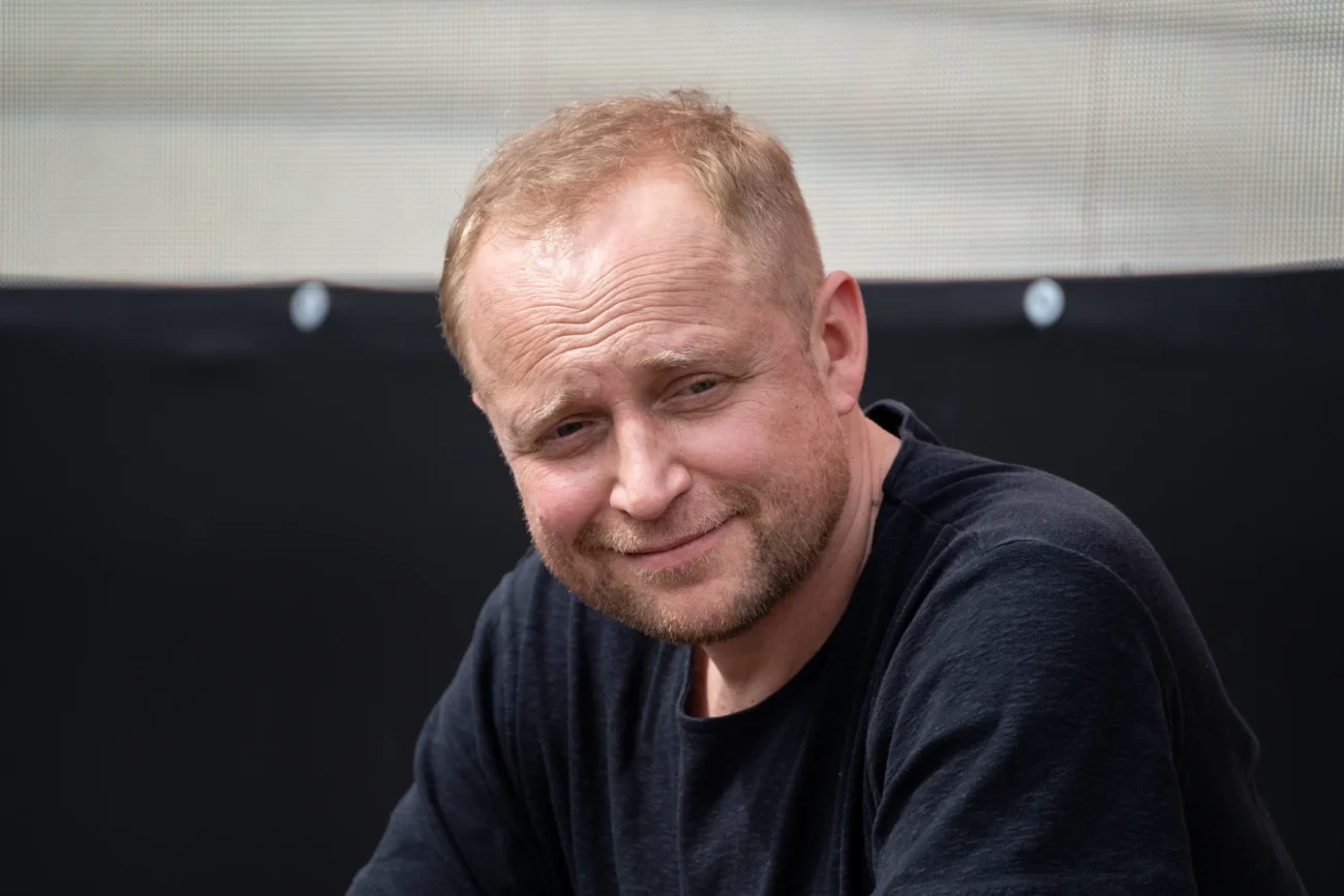 Muž sedí a kouká.