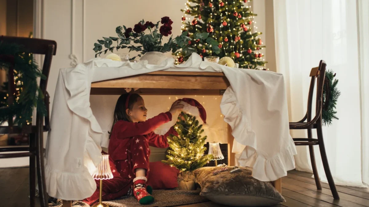 Děti si hrají po vánočně vyzdobeným stolkem.