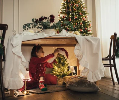 Děti si hrají po vánočně vyzdobeným stolkem.