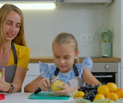 Matka s dcerou krájí ovoce.
