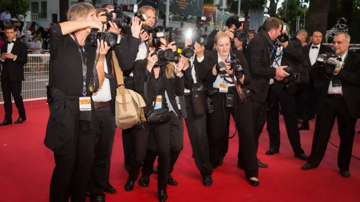 Lidé stojí na červeném koberci.