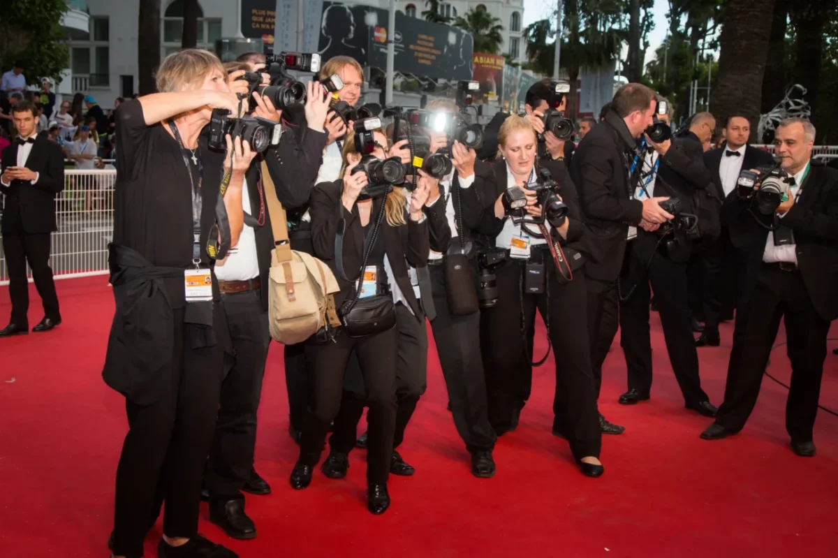 Lidé stojí na červeném koberci.