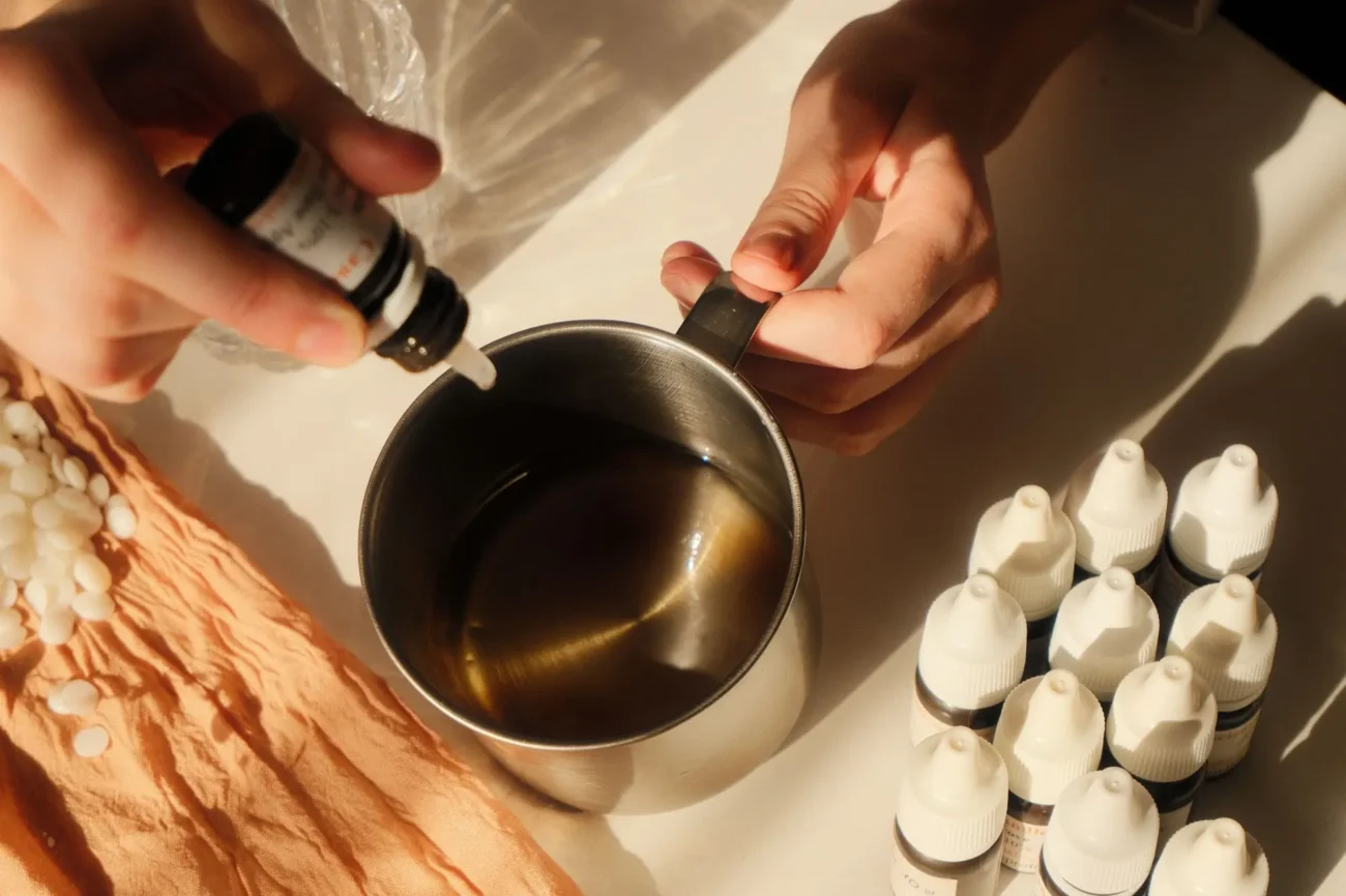 slečna přidává esenciální olej do rozehřátého vosku