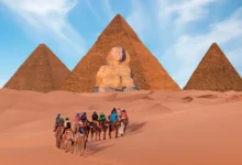 Lidé jedou na koních směrem k pyramidám.