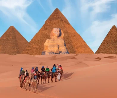 Lidé jedou na koních směrem k pyramidám.