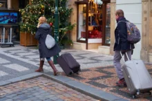 Lidé se prochází s kufrem.