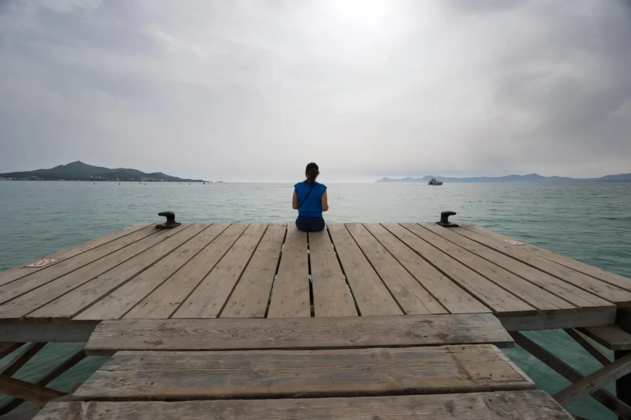 paní sedí na mole a nedělá nic