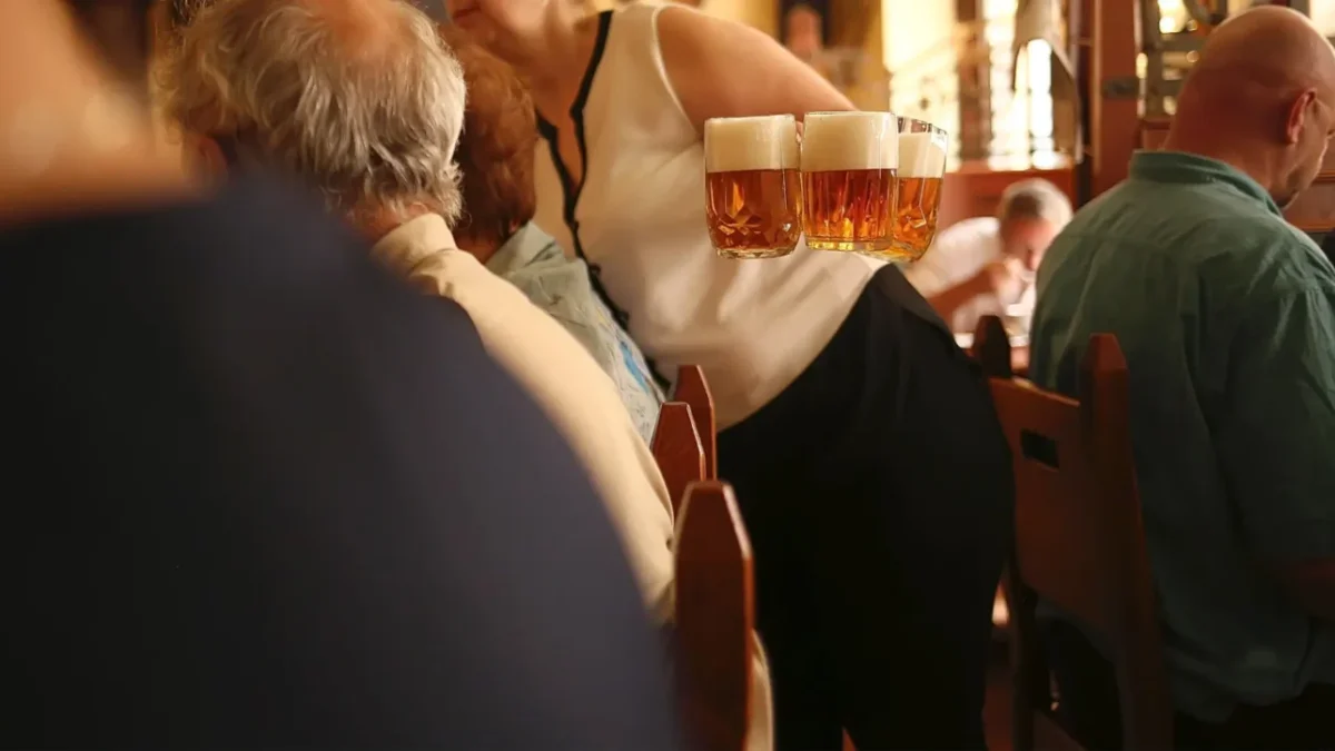 servírka nese tři čepovaná piva