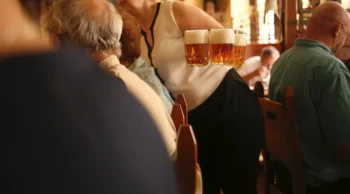 servírka nese tři čepovaná piva