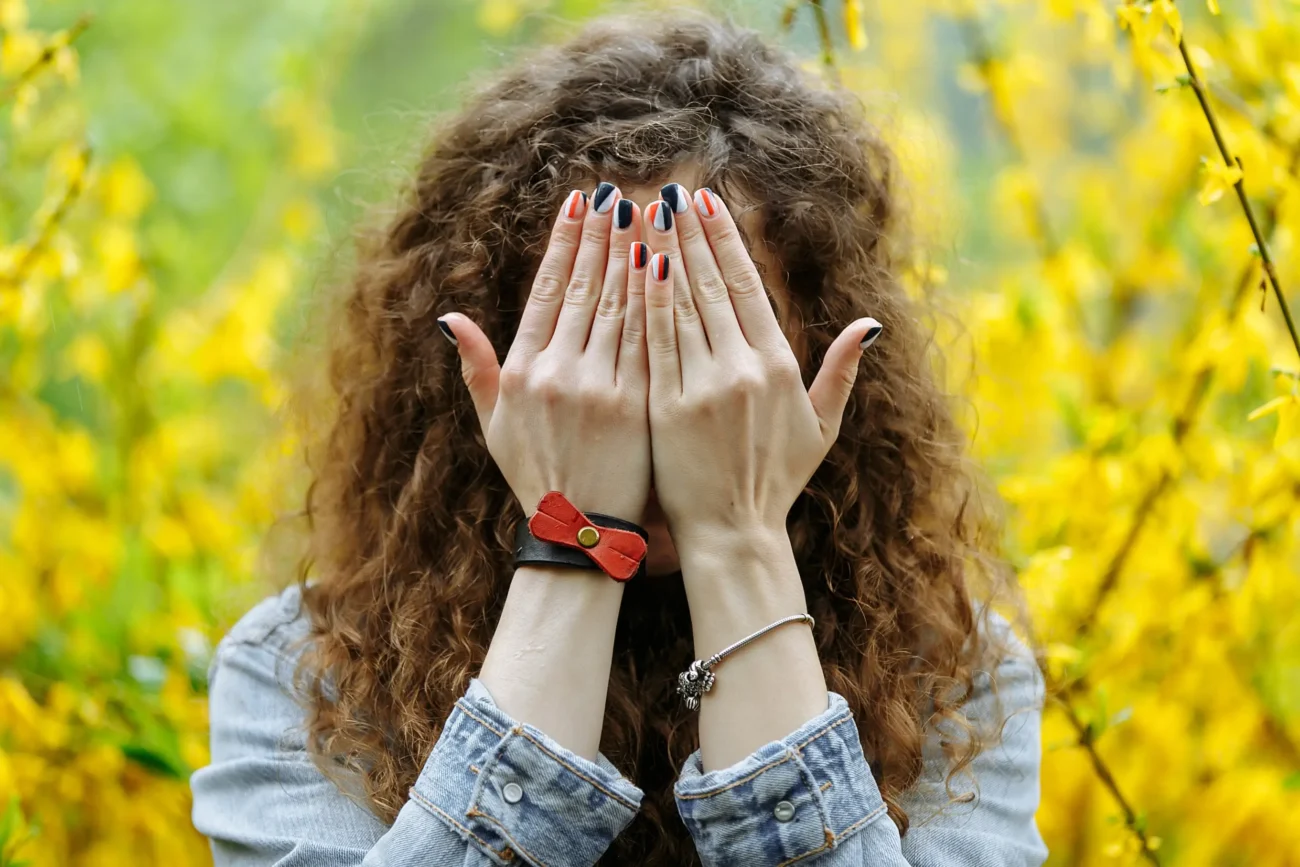 Žena si rukama ukrývá obličej.