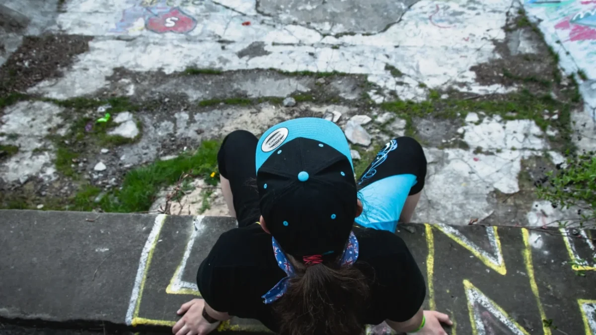 Člověk sedí na okraji barrandovského bazénu.