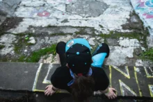 Člověk sedí na okraji barrandovského bazénu.