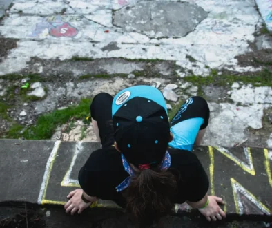 Člověk sedí na okraji barrandovského bazénu.