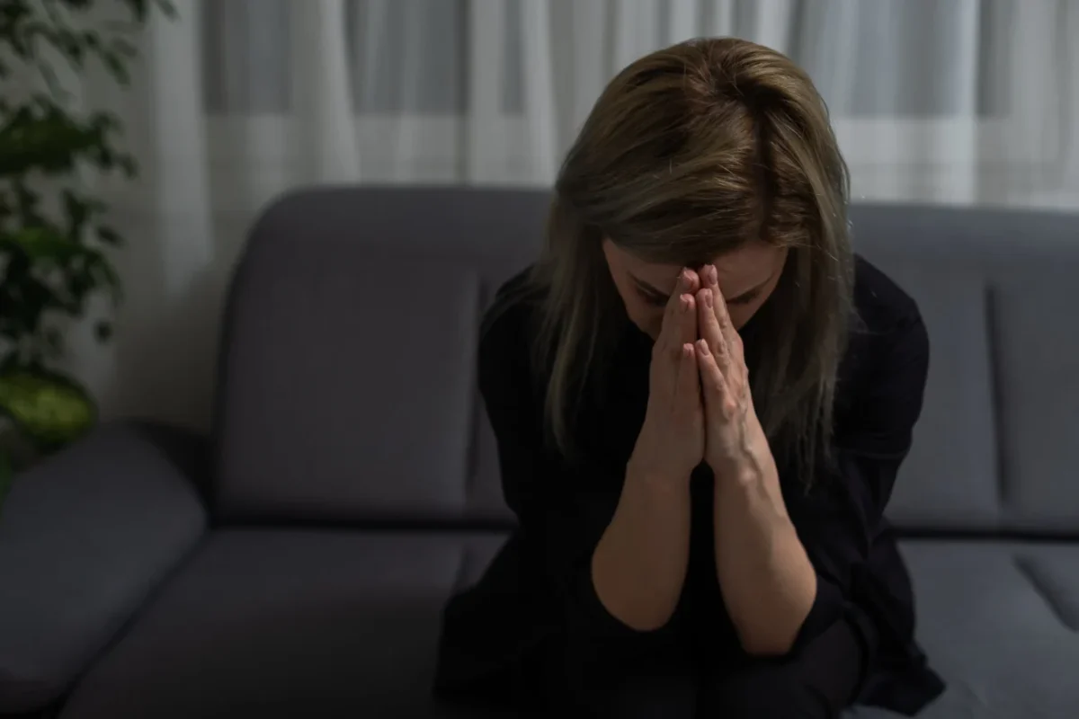 Žena sedí a truchlí.
