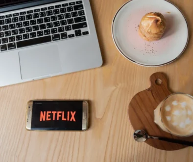 Na stole leží občerstvení a mobil s Netflixem.