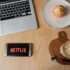 Na stole leží občerstvení a mobil s Netflixem.
