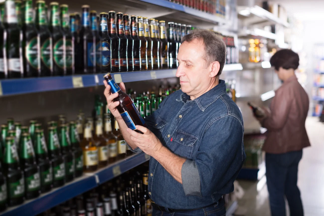 Muž nakupuje pivo. 