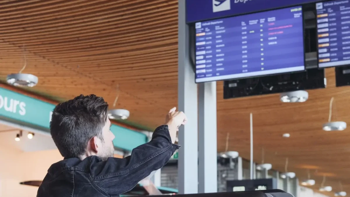 Muž ukazuje na ceduli s odlety.