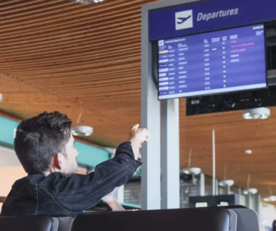 Muž ukazuje na ceduli s odlety.