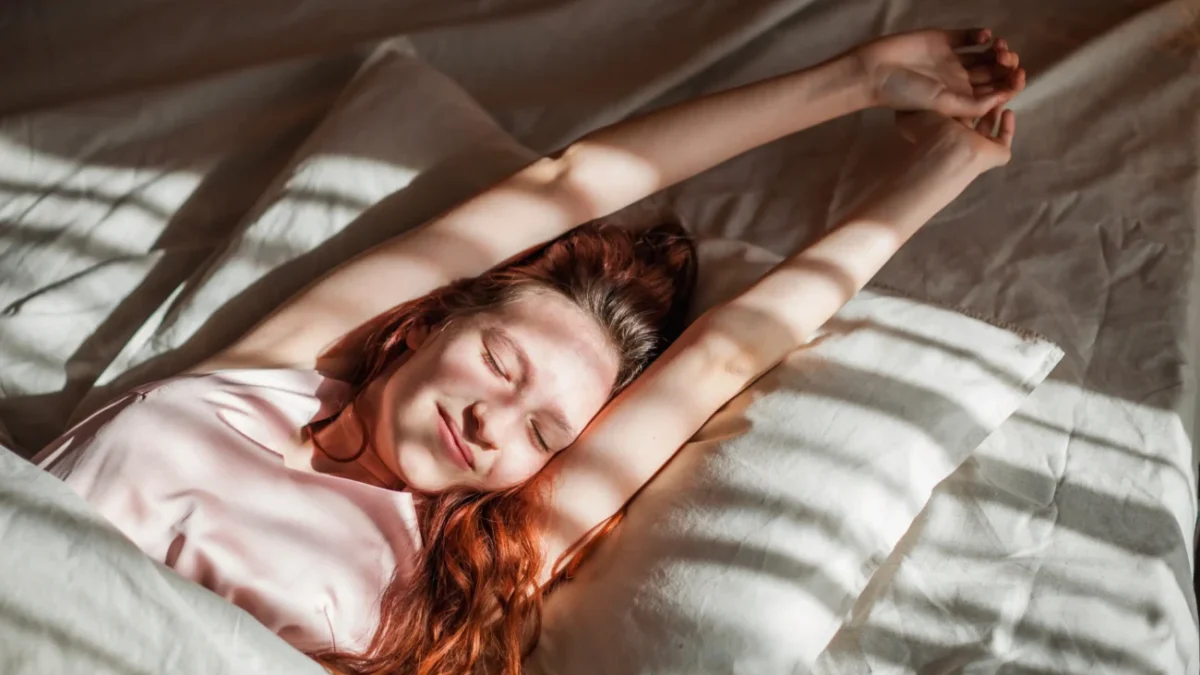 Žena se protahuje v posteli.