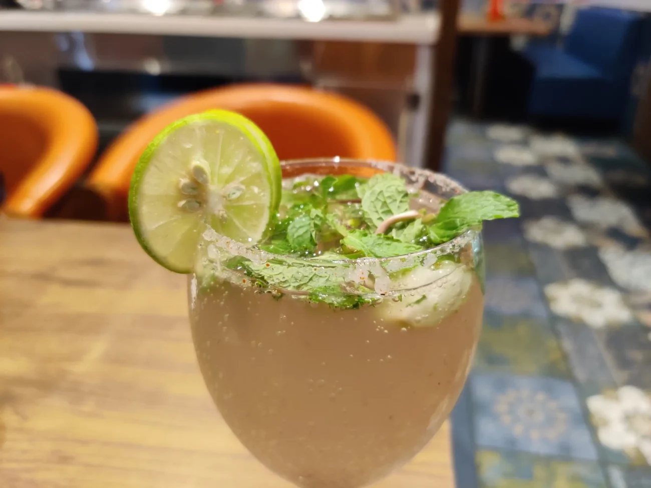 Na stole stojí sklenka s mojitem.