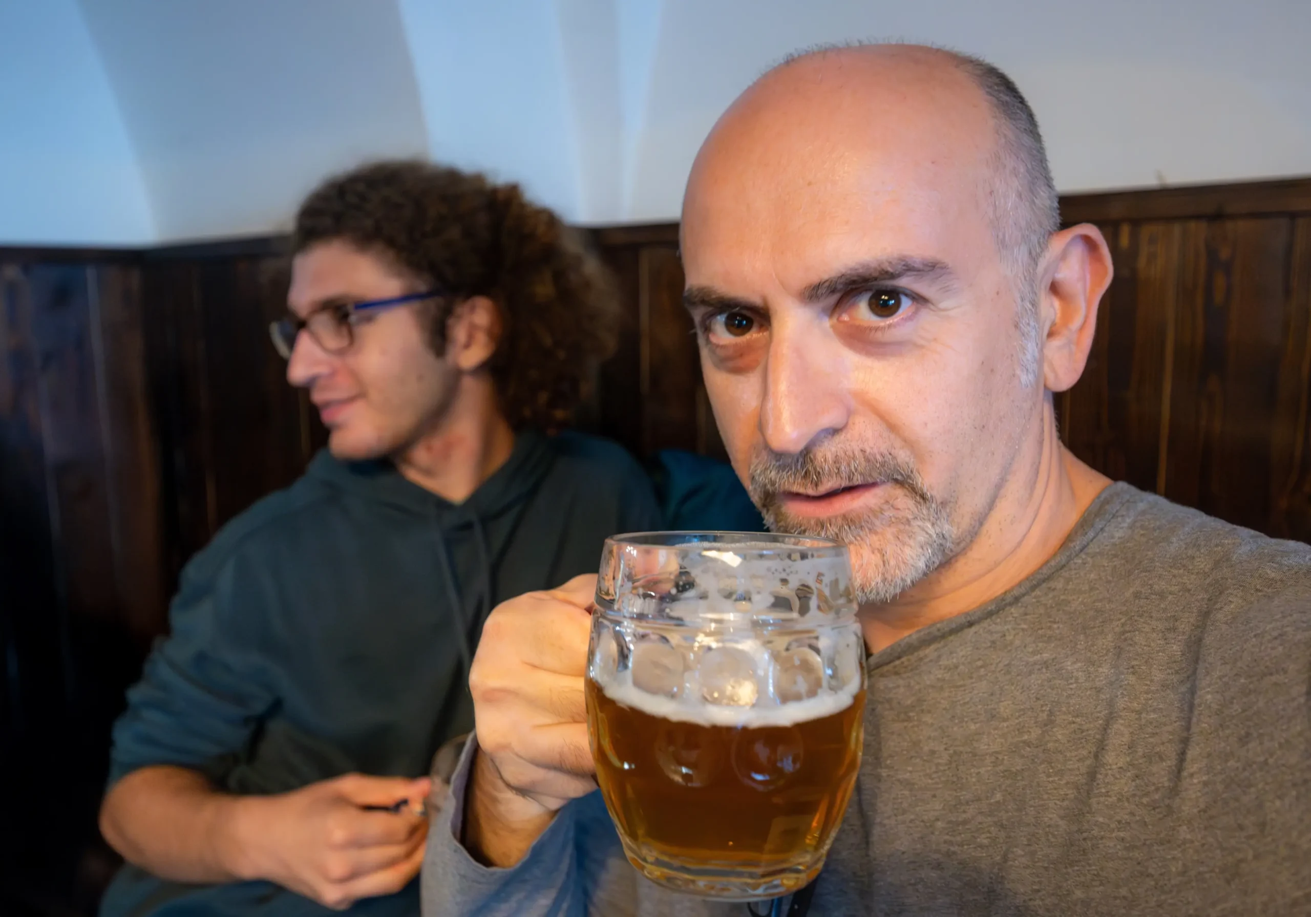 Muž v ruce drží sklenici s pivem.