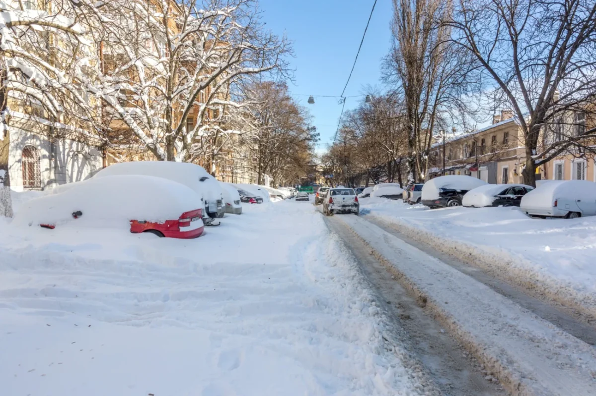 Zasněžená ulice s auty.