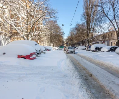 Zasněžená ulice s auty.