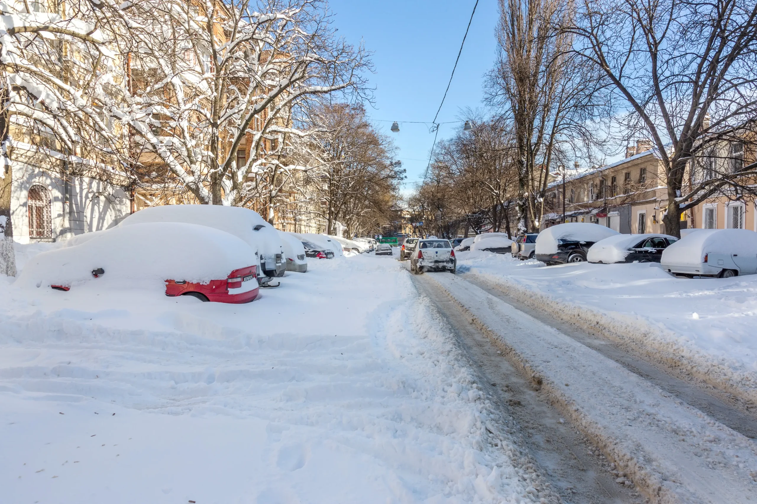 Zasněžená ulice s auty.