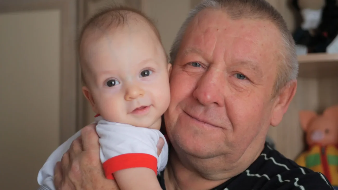 Dědeček objímá miminko. 