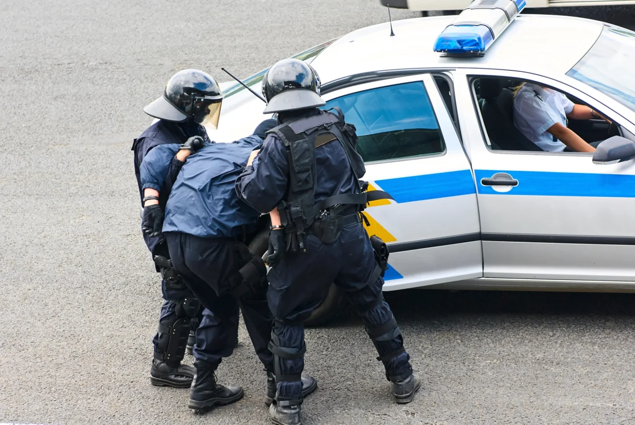 Policisté do auta vlečou muže.