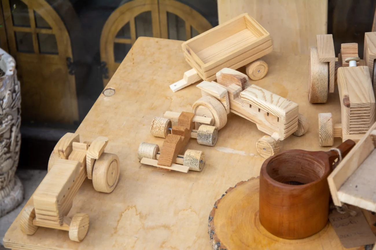 Na stole leží dřevěné hračky.