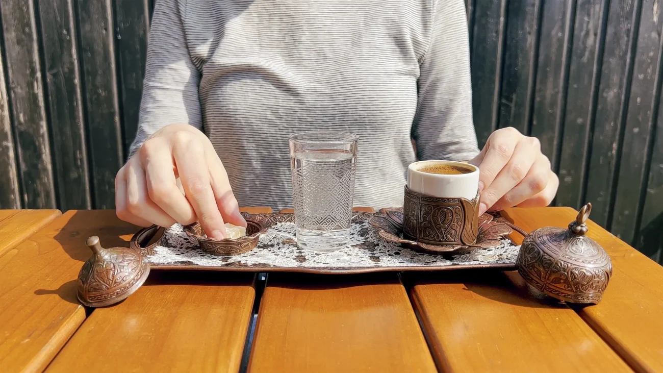 shutterstock_2436750447-2 | TVGURU.cz Žena si na stole připravuje kávu.