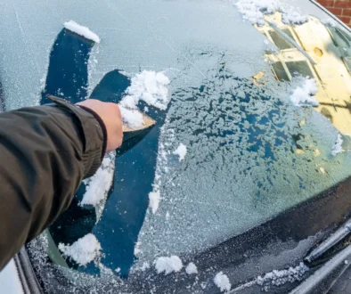 člověk škrábe sklo auta