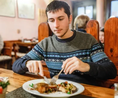 Muž sedí v restauraci a jí.