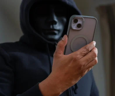 Muž v masce kouká na telefon.