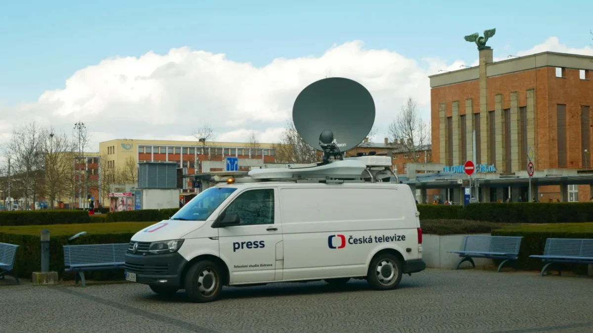 Před budovou parkuje auto ČT1.